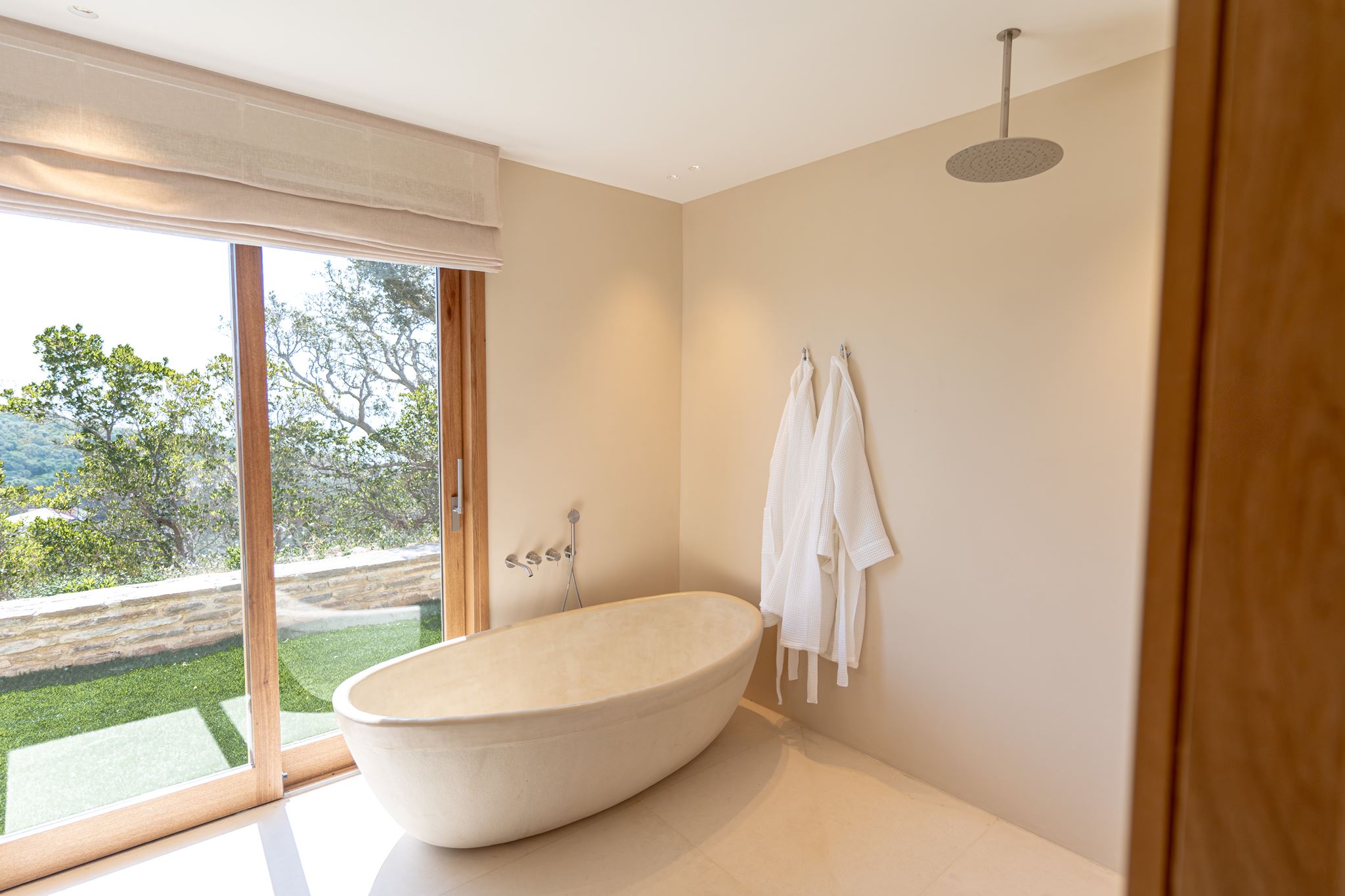 Baignoire îlot en pierre et peignoirs, salle de bain d'un hôtel de prestige